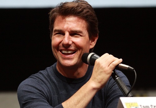 Actor Tom Cruise grining behind a mic
