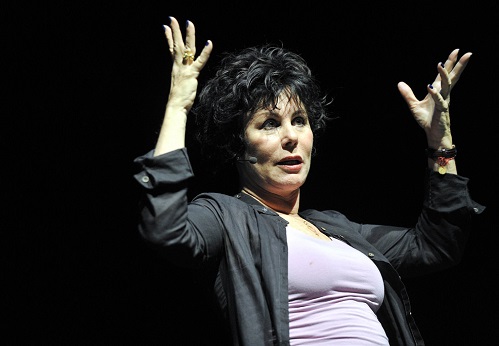 Ruby Wax waving her hands on stage
