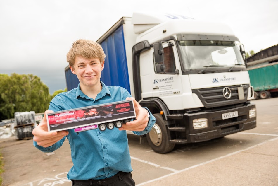 Ed Hollands posing in front of his truck with a small model truck in his hands